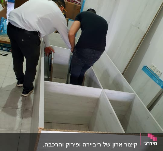 שני אנשים מרכיבים ארון עץ בחדר